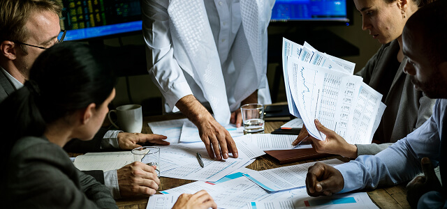 Professionals in collaborative meeting reviewing documents